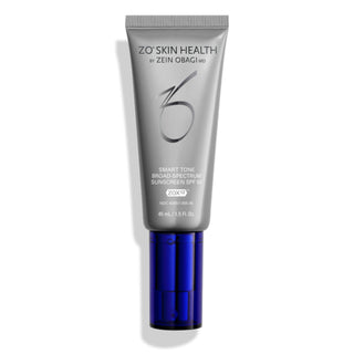 A silver tube labeled "ZO Skin Health by Zein Obagi MD, Smart Tone Broad Spectrum Sunscreen SPF 50 (ZOX12)," with a blue pump and cap, containing 45 ml or 1.5 fl. oz. of product